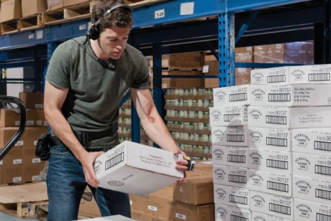 Warehouse worker using voice picking technology in inventory management